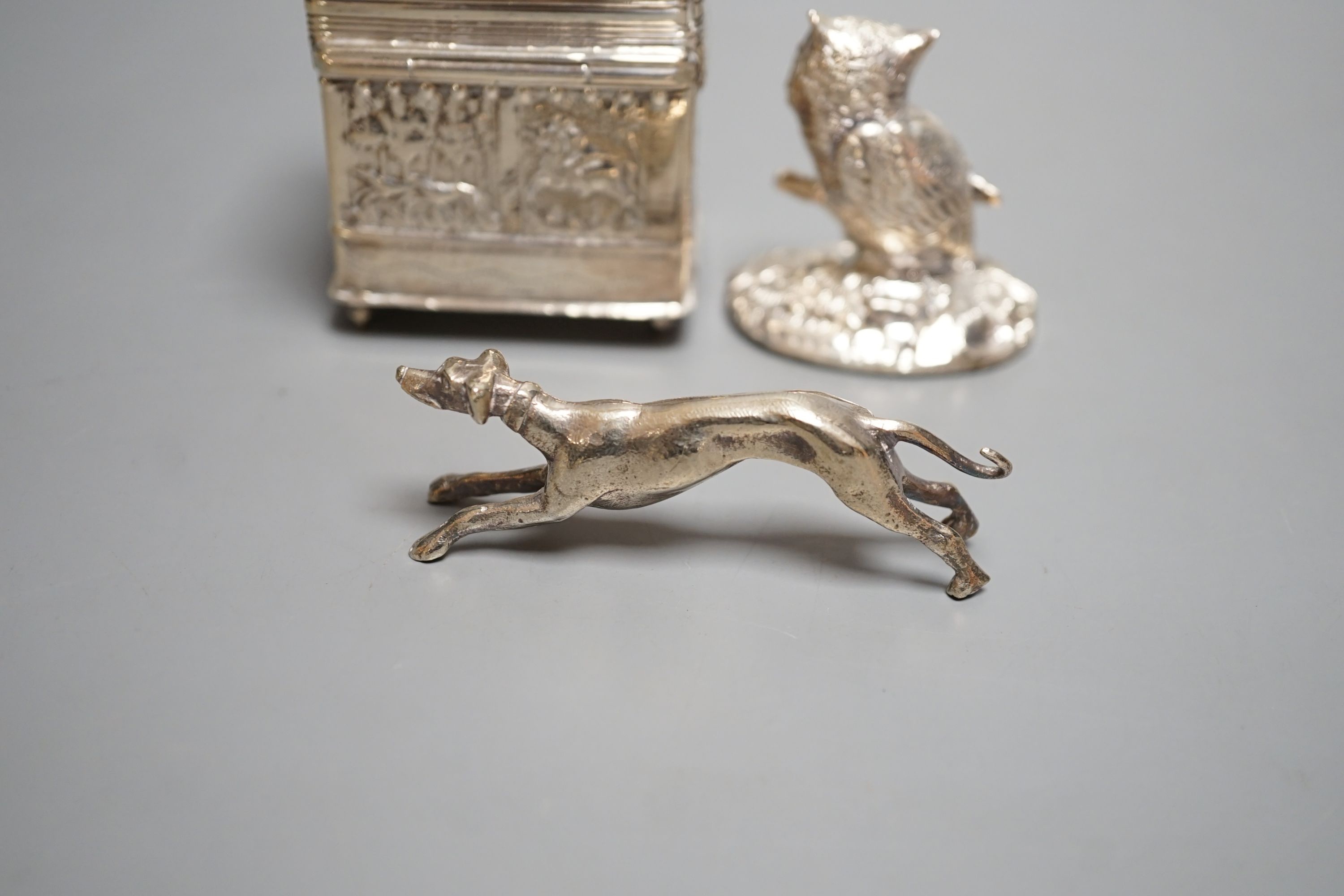 A continental embossed silver box, with import marks for London, 1903, 65mm, a modern silver filled model owl and a metal model of a dog.